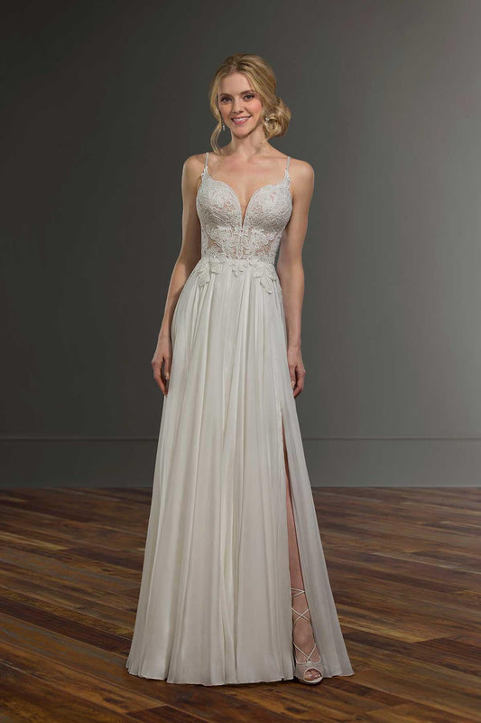 A stunning bride wearing a sleeveless, A-line wedding gown with a plunging V-neckline. The bodice features intricate lace detailing, creating a romantic and delicate look, while the flowing chiffon skirt includes a daring thigh-high slit, adding a touch of modern elegance. The gown is completed with subtle straps and a floor-length hem, perfectly blending classic and contemporary bridal style.