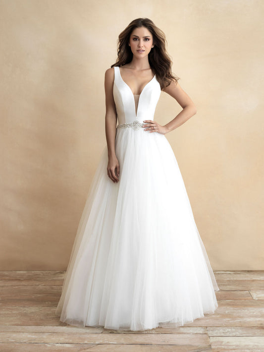 Stunning ball gown wedding dress featuring a deep V-neckline and a tulle skirt, accented with a jeweled waistband for added elegance. Ideal for brides seeking a classic yet glamorous look.