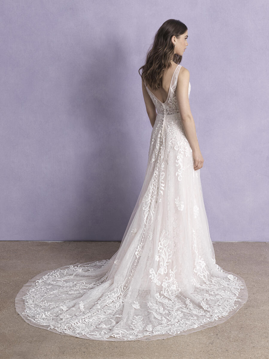 Back view of a lace wedding dress with a plunging V-back and elegant floral embroidery, featuring a flowing train that adds a touch of grace to this timeless bridal gown.