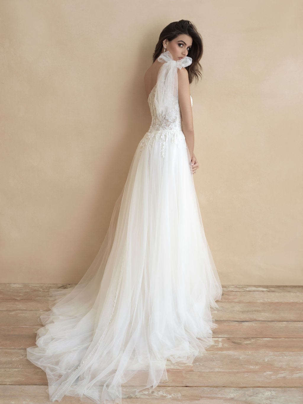 Elegant tulle wedding dress with a delicate high neckline, open back, and flowing train, offering a timeless and graceful bridal look.