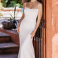 Sleek, fitted wedding gown featuring a low back and button detail down the long, flowing train. A modern, minimalist bridal look for an elegant outdoor ceremony.