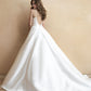 Elegant ball gown wedding dress with a deep V-back and dramatic train, adorned with delicate button detailing. A perfect choice for brides seeking a blend of classic beauty and modern sophistication.
