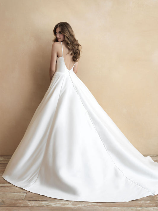 Elegant ball gown wedding dress with a deep V-back and dramatic train, adorned with delicate button detailing. A perfect choice for brides seeking a blend of classic beauty and modern sophistication.