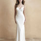 Sleek satin wedding dress with a deep V-neckline, subtle floral lace appliqués, and a fitted silhouette for the modern bride seeking understated elegance and sophistication.