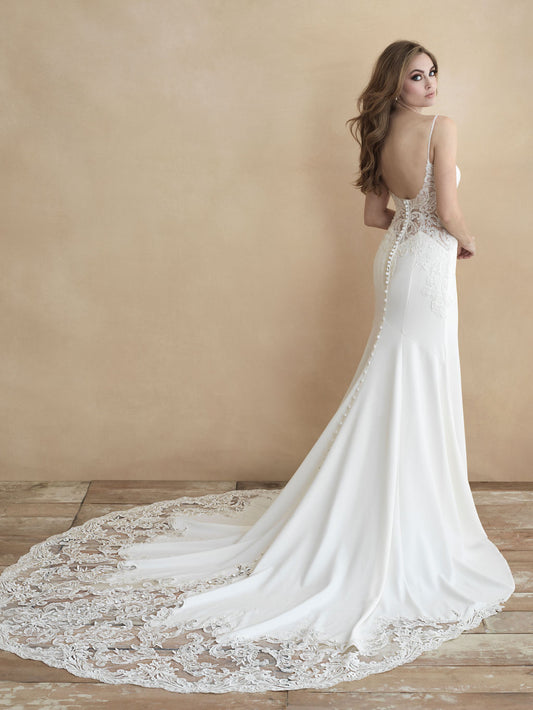 Elegant bridal gown featuring a low scoop back, delicate lace detailing on the train, and a form-fitting silhouette. Perfect for brides who desire a blend of modern sophistication and timeless romance.