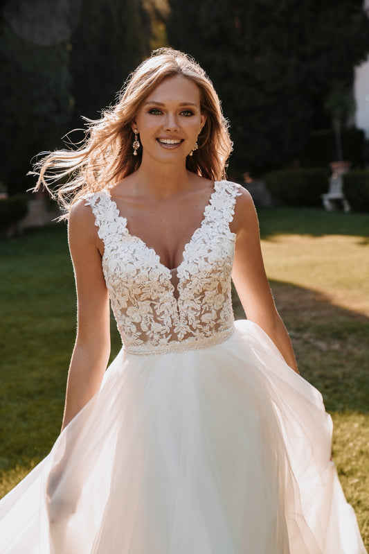 Romantic lace bodice with a plunging neckline and flowing tulle skirt, perfect for the free-spirited bride looking for a blend of elegance and whimsy.