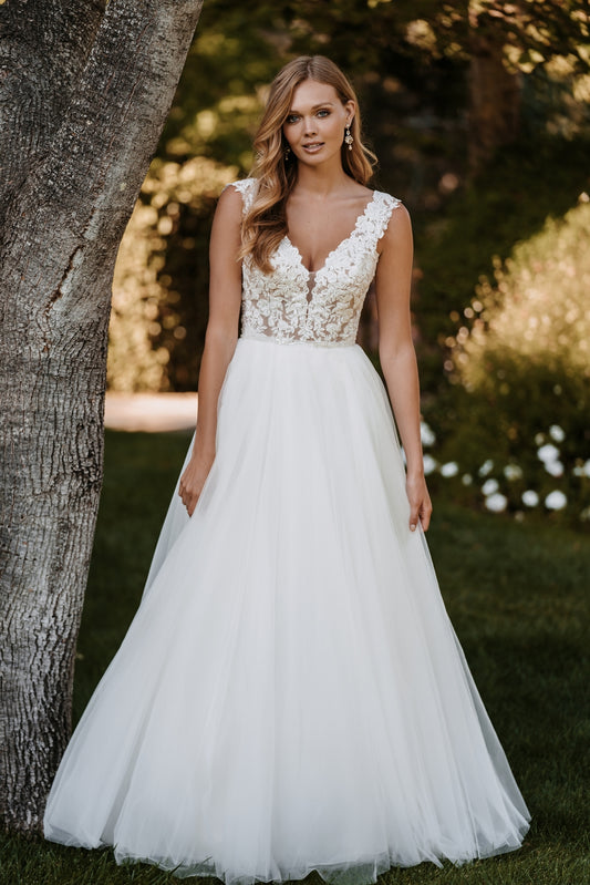 Romantic lace bodice with a plunging neckline and flowing tulle skirt, perfect for the free-spirited bride looking for a blend of elegance and whimsy.