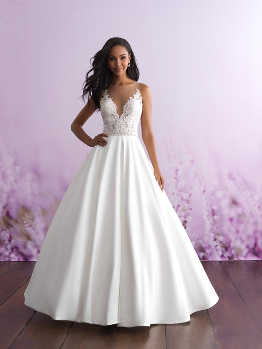 Stunning ball gown wedding dress with a deep V-neckline and intricate lace bodice, complemented by a luxurious satin skirt. Ideal for brides seeking a classic, yet modern bridal look.