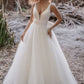 Classic ball gown wedding dress with a deep V-neckline and a voluminous tulle skirt, perfect for a bride seeking a timeless yet modern look for a romantic outdoor or destination wedding.