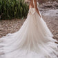 Classic ball gown wedding dress with a deep V-neckline and a voluminous tulle skirt, perfect for a bride seeking a timeless yet modern look for a romantic outdoor or destination wedding.