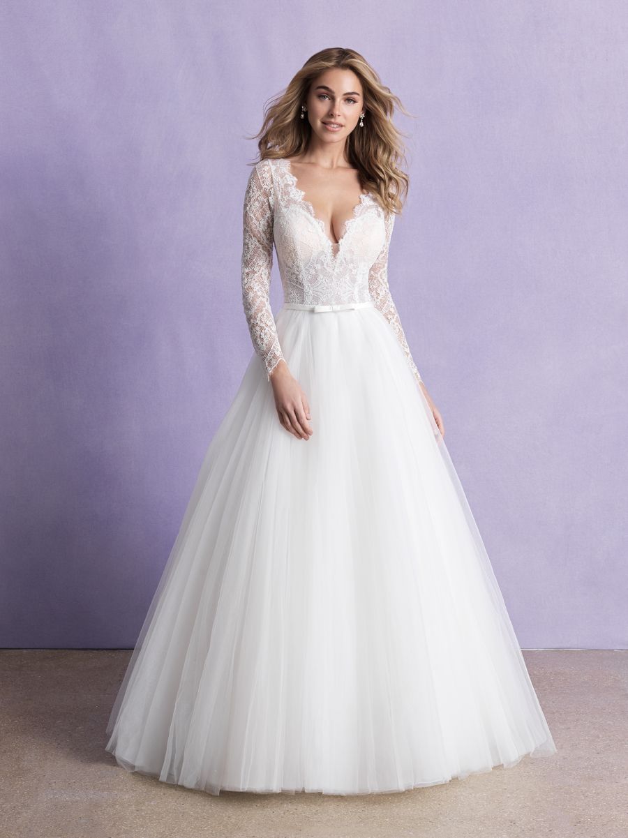 Step into timeless beauty with this lace long-sleeve bridal gown, featuring a plunging neckline and a full tulle skirt. Perfect for the bride seeking elegance and sophistication on her wedding day.